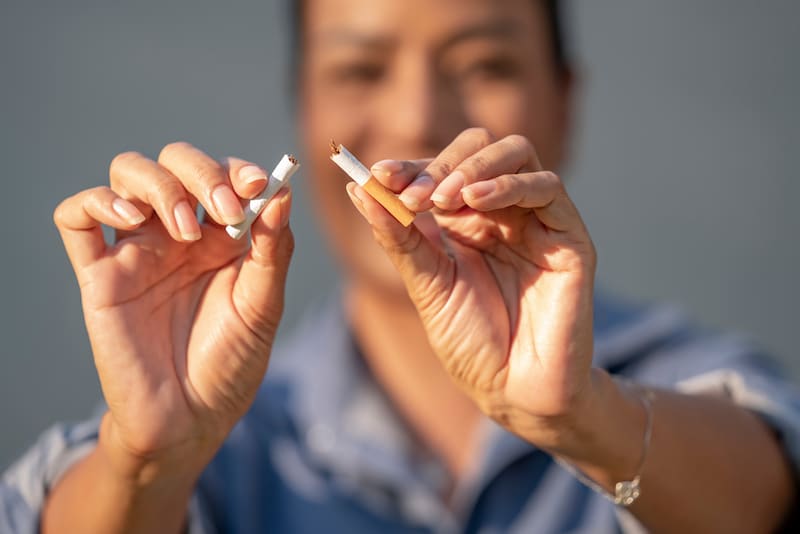 Woman snapping cigarette in half