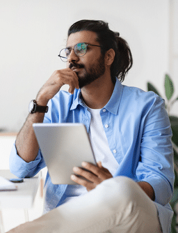 male sitting with tablet considering filing a sexual harrassment case