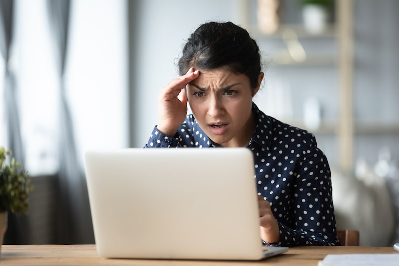 Shocked woman reading a message on her laptop